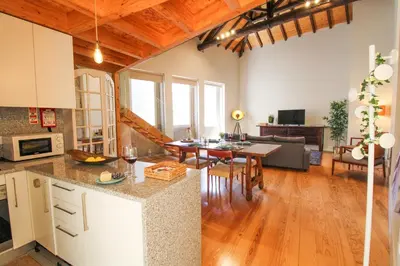a kitchen and living room with a table and a couch at Mouzinho Mezzanine in Porto