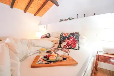 a table with a tray of fruit on a bed at Mouzinho Mezzanine in Porto
