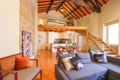 a living room with a blue couch and a kitchen at Mouzinho Mezzanine in Porto