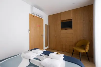 a hotel room with a bed and a chair at Coruja’s House AL OPO in Porto
