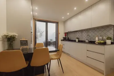 a kitchen with a table and chairs and a counter at Coruja’s House AL OPO in Porto