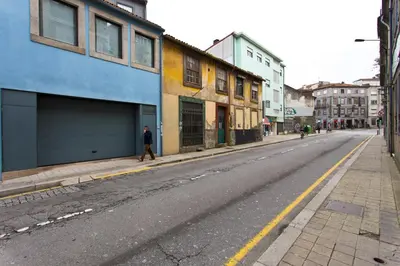 a man walking down an empty city street at Host Wise - Spacious Trendy Flat w Netflix - Central Location in Porto