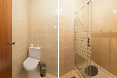 a bathroom with a toilet and a glass shower at Host Wise - Spacious Trendy Flat w Netflix - Central Location in Porto
