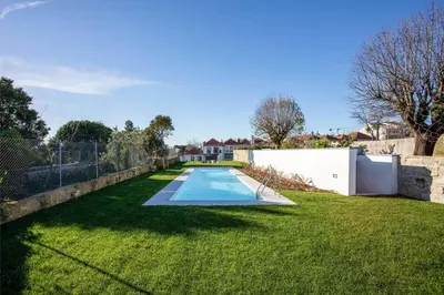 a backyard with a swimming pool in the grass at Liiiving in Porto - Haven Pool Apartment in Porto