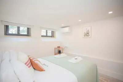a white room with a bed and a couch at Liiiving in Porto - Haven Pool Apartment in Porto
