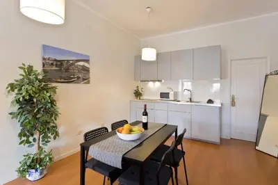 a kitchen and dining room with a table with a bowl of fruit at Host Wise - Cozy Sunny Flats - Ace Location in Porto