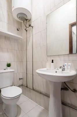a bathroom with a toilet and a sink and a mirror at Host Wise - Cozy Sunny Flats - Ace Location in Porto