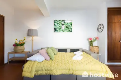 a bedroom with a bed with a yellow blanket at Host Wise - Comfy Bright Flats with Netflix in Porto
