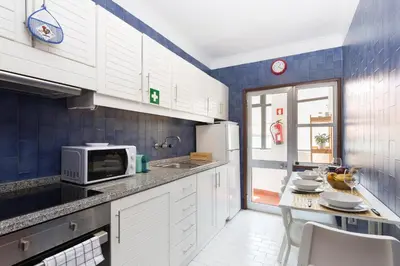 a kitchen with white cabinets and a microwave at Host Wise - Comfy Bright Flats with Netflix in Porto
