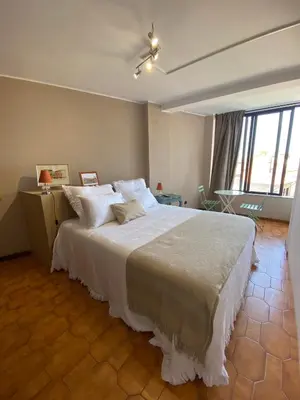 a bedroom with a large bed with white sheets at Jardim do Morro Places in Vila Nova de Gaia