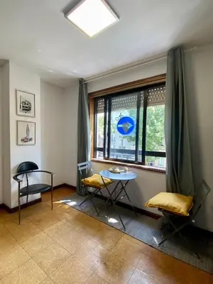 a room with a table and chairs and a window at Jardim do Morro Places in Vila Nova de Gaia