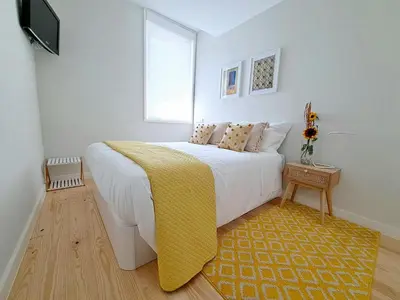 a bedroom with a large bed with a yellow blanket at Boavista Luxury Villas in Porto