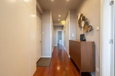 a hallway of a home with a wooden floor at Carolina Roomy & Modern Apartment in Porto