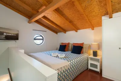 a bedroom with a bed with blue and orange pillows at Host Wise - Impressive Restful Houses in Porto
