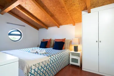 a bedroom with a bed with blue and orange pillows at Host Wise - Impressive Restful Houses in Porto