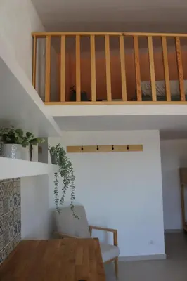 a living room with a wooden table and a staircase at Casas da Corujeira in Porto