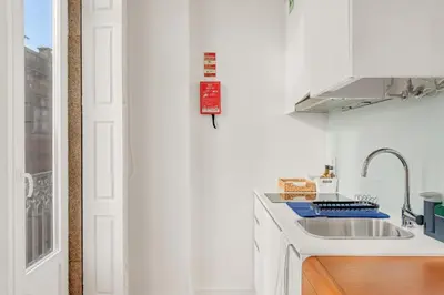 a white kitchen with a sink and a counter at Host Wise - Lovely Shinny Flats with Balcony - Clerigos in Porto