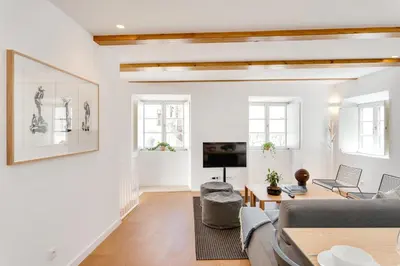 a living room with a couch and a tv at Miragaia Apartments by DA'HOME in Porto