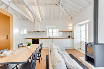 a living room with a table and a couch and a fireplace at Miragaia Apartments by DA'HOME in Porto