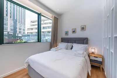 a bedroom with a large white bed and a large window at Window to Porto by Amber Star Rent in Porto