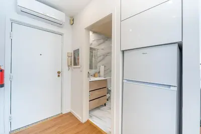 a kitchen with white cabinets and a door leading into a closet at Window to Porto by Amber Star Rent in Porto