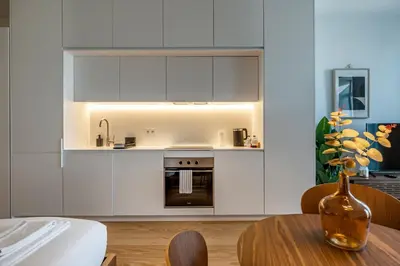 a kitchen with white cabinets and a wooden table at Nomad's Lux - Almada Apartments Porto in Porto