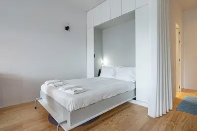 a bedroom with a white bed with a mirror at Nomad's Lux - Almada Apartments Porto in Porto