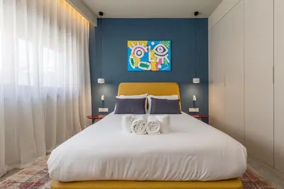 a bedroom with a large white bed with a blue wall at Aspasios Bonjardim Apartments in Porto