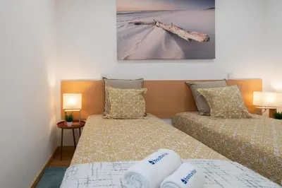 a bedroom with two beds with towels on them at Host Wise - Colorful Fresh Flats - Batalha in Porto