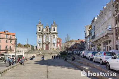 a group of people walking down a city street with a church at Host Wise - Colorful Fresh Flats - Batalha in Porto