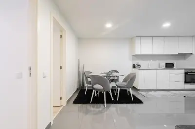 a dining room with a table and chairs in a kitchen at Host Wise - Spacious Noble Apartaments Ace Location in Porto