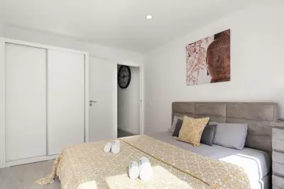 a white bedroom with a bed with white shoes on it at Host Wise - Spacious Noble Apartaments Ace Location in Porto