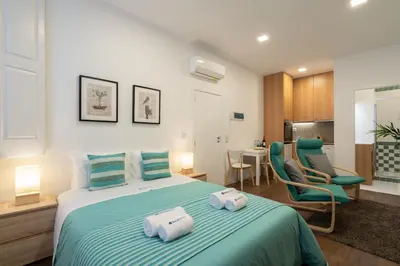 a bedroom with a large bed with two towels on it at Host Wise - Modern Studios with Terrace - Walk Everywhere in Porto