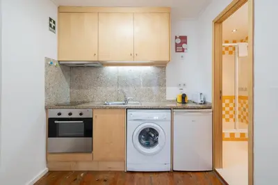 a kitchen with a washing machine and a washer at Host Wise - Modern Studios with Terrace - Walk Everywhere in Porto