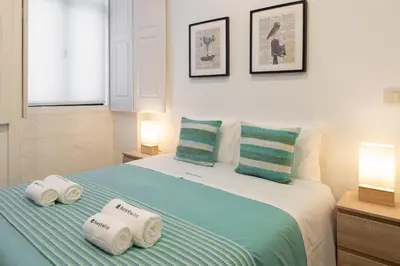 a bedroom with a bed with three towels on it at Host Wise - Modern Studios with Terrace - Walk Everywhere in Porto