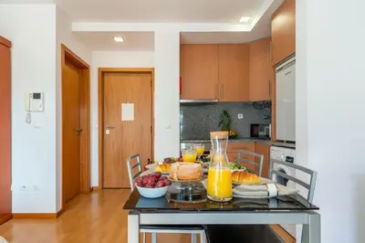 a kitchen with a table with fruit and orange juice at Host Wise - Bright Quiet Flats - Prime Location in Porto