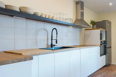 a kitchen with white cabinets and a sink at Host Wise - Fantastic Contemporary Flat w Balcony in Porto