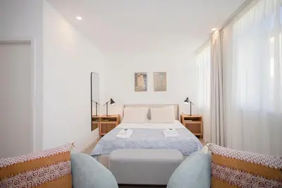 a bedroom with a bed and two chairs at Liiiving in Porto - Urban Art Apartment in Porto