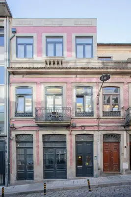 a pink brick building with windows and a balcony at Liiiving in Porto - Urban Art Apartment in Porto