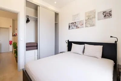a bedroom with a white bed and a hallway at Dennis Family Friendly House by RDC in Porto