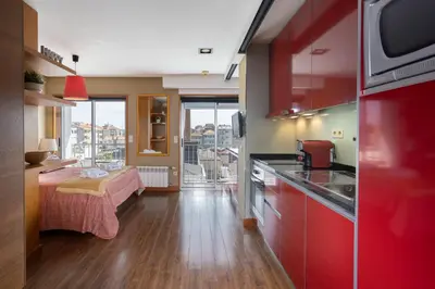 a kitchen with red cabinets and a table in a room at Host Wise - Bright Fresh Flat with Garage - Marquês in Porto