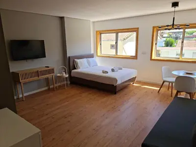 a bedroom with a bed and a flat screen tv at Campanhã Studio in Porto