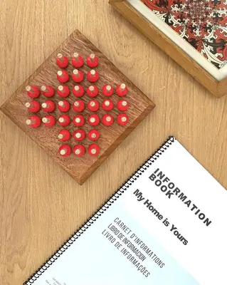 a board with red balls on a table next to a paper at My Home is Yours in Porto