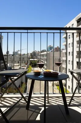 a table with two glasses of wine on a balcony at My Home is Yours in Porto
