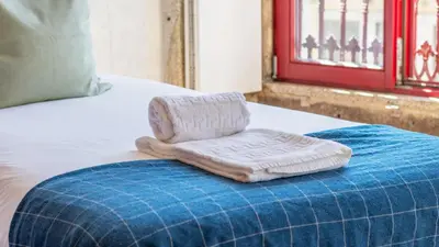 a towel sitting on top of a bed at Bento Living by LovelyStay in Porto