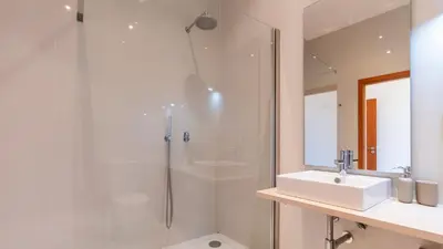 a bathroom with a shower and a sink and a mirror at Bento Living by LovelyStay in Porto