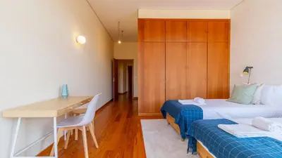 a hotel room with two beds and a desk at Bento Living by LovelyStay in Porto