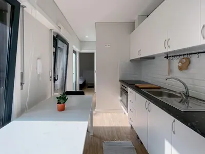 a white kitchen with a sink and a counter at Casas S. Dinis in Porto