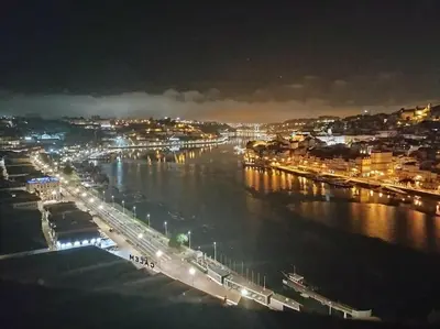 a view of a city at night with the water at Loft in the historic center of Oporto downtown in Porto