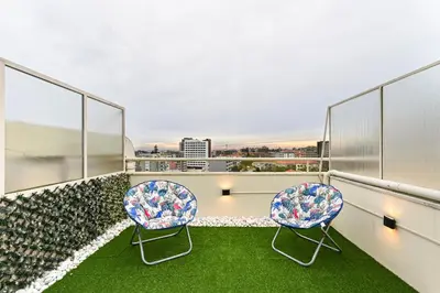 two chairs on a balcony with a view of the city at Julio Dinis Porto Secret Retreat - by Guest SPA in Porto